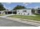 Charming single-story home with carport, well-maintained lawn, and beautiful landscaping at 105 Avocado Cv, Leesburg, FL 34748