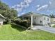 Single-story home with carport and well-maintained garden with lush landscaping at 105 Avocado Cv, Leesburg, FL 34748