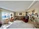Bright living room featuring a sectional sofa, accent chair, and natural light streaming through large windows at 105 Avocado Cv, Leesburg, FL 34748