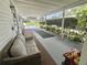 Cozy covered porch with seating, garden area and shaded entrance to home at 105 Avocado Cv, Leesburg, FL 34748
