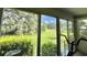 Sun room with a view of the lush backyard that includes a pond and mature trees at 105 Avocado Cv, Leesburg, FL 34748