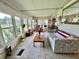 Bright sunroom with large windows showcasing serene outdoor views, offering a relaxing space with ample seating at 105 Avocado Cv, Leesburg, FL 34748
