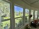 Picturesque view from the sunroom windows, overlooking lush greenery and a tranquil pond, creating a serene ambiance at 105 Avocado Cv, Leesburg, FL 34748