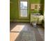 Spacious bedroom with hardwood floors, a vibrant green wall, and a vintage-style sink at 110 S Trowell Ave, Umatilla, FL 32784