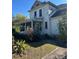 Two-story home with enclosed porch, showing peeling paint and overgrown landscaping at 110 S Trowell Ave, Umatilla, FL 32784