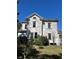 Multi-story home showcasing architectural details and a well-maintained lawn at 110 S Trowell Ave, Umatilla, FL 32784