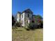 Two story home surrounded by a grass yard with trees and bushes at 110 S Trowell Ave, Umatilla, FL 32784