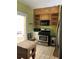 View of the kitchen featuring outdated appliances, cabinetry, and tile flooring at 110 S Trowell Ave, Umatilla, FL 32784