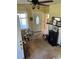 Cozy living room with a ceiling fan, front door, a stack of books and a faux fireplace against a yellow painted wall at 110 S Trowell Ave, Umatilla, FL 32784