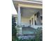 Front porch with white pillars, a concrete floor and various plants nearby at 110 S Trowell Ave, Umatilla, FL 32784