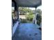 Covered porch with view of the greenery and street, presenting an opportunity for upgrades at 110 S Trowell Ave, Umatilla, FL 32784