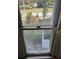 Close-up of a window with view of the trees and surrounding neighborhood at 110 S Trowell Ave, Umatilla, FL 32784