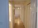 Bright hallway with tile floors and storage closets leading to rooms with neutral carpeting for easy personalization at 1108 Apple Ter, Leesburg, FL 34748