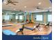 Bright aerobics room featuring hardwood floors, ceiling fans, and mirrored walls for a complete fitness experience at 1180 Mesa Verde Ct, Clermont, FL 34711