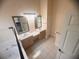 Bathroom with double sink vanity, framed mirrors, and a separate glass-enclosed shower and tub area at 1180 Mesa Verde Ct, Clermont, FL 34711