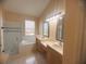 Bathroom featuring a glass-enclosed shower, soaking tub, double sink vanity with neutral countertops and cabinetry at 1180 Mesa Verde Ct, Clermont, FL 34711