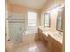 Bathroom featuring a glass-enclosed shower, soaking tub, double sink vanity with neutral countertops and cabinetry at 1180 Mesa Verde Ct, Clermont, FL 34711