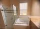 Bright bathroom featuring a glass-enclosed shower, a soaking tub, and a window for natural light at 1180 Mesa Verde Ct, Clermont, FL 34711