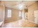 Spacious bedroom with neutral walls, tile flooring, a ceiling fan, and multiple windows providing natural light at 1180 Mesa Verde Ct, Clermont, FL 34711