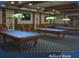 Spacious billiard room featuring three pool tables and traditional lighting fixtures at 1180 Mesa Verde Ct, Clermont, FL 34711