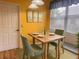 Cozy dining area features a rustic wooden table, green chairs, and natural light from the window at 1180 Mesa Verde Ct, Clermont, FL 34711