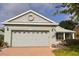 Well-maintained home showcasing a spacious garage, neat landscaping, and a decorative gable detail at 1180 Mesa Verde Ct, Clermont, FL 34711