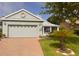 Charming single-story home with well-maintained landscaping, a brick driveway, and a cozy front porch at 1180 Mesa Verde Ct, Clermont, FL 34711