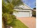 Spacious two-car garage with decorative windows and a brick-paved driveway, enhancing the home's curb appeal at 1180 Mesa Verde Ct, Clermont, FL 34711