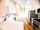 Spacious kitchen featuring white cabinets, stainless steel appliances, and hardwood floors that transition to the living room at 1180 Mesa Verde Ct, Clermont, FL 34711