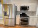Close-up view of stainless steel refrigerator and stove in a modern kitchen setting at 1180 Mesa Verde Ct, Clermont, FL 34711