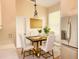 Inviting kitchen with a stylish dining table, white chairs, stainless steel refrigerator, and bright, natural light at 1180 Mesa Verde Ct, Clermont, FL 34711