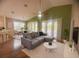 Open-concept living room showcasing a sofa and bar seating with natural light through large windows at 1180 Mesa Verde Ct, Clermont, FL 34711
