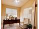 Home office with a desk, comfortable seating, wainscotting, and ample natural light from two windows at 1180 Mesa Verde Ct, Clermont, FL 34711