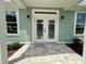 Welcoming front entrance with double doors, sconces, and tiled walkway at 12110 Grand Oak Ln, Oxford, FL 34484