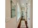Hallway featuring wood floors, coastal artwork, and leads to a bedroom with natural light at 12110 Grand Oak Ln, Oxford, FL 34484