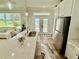 Bright kitchen with granite counters, stainless steel appliances, and hardwood floors at 12110 Grand Oak Ln, Oxford, FL 34484