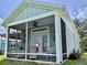 Enclosed porch with ceiling fan and seating, perfect for enjoying the outdoors at 12110 Grand Oak Ln, Oxford, FL 34484