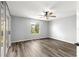 Cozy bedroom featuring neutral walls, wood-look floors, and a window with a view at 1224 Ballesteros Dr, The Villages, FL 32162