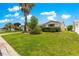Charming home featuring a well-manicured lawn with mature landscaping and a beautiful palm tree at 1224 Ballesteros Dr, The Villages, FL 32162