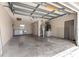 Spacious garage with laundry area, shelving, and plenty of room for storage at 1224 Ballesteros Dr, The Villages, FL 32162