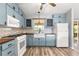 Updated kitchen with blue cabinets, butcher block counters, and white appliances at 1224 Ballesteros Dr, The Villages, FL 32162