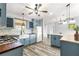 Modern kitchen features blue cabinetry, butcher block counters, and mosaic backsplash at 1224 Ballesteros Dr, The Villages, FL 32162