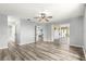 Spacious living room with sliding glass doors leading to a covered patio and wood-look floors at 1224 Ballesteros Dr, The Villages, FL 32162