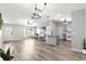 Inviting living space showcasing vinyl floors, contemporary lighting, and functional kitchen access at 1224 Ballesteros Dr, The Villages, FL 32162