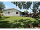 Expansive backyard with a well-maintained lawn and a wooden deck attached to the rear of the house at 1301 Cambridge Dr, Leesburg, FL 34748