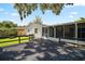 Backyard with a wooden deck, screened patio, and grassy area with mature trees at 1301 Cambridge Dr, Leesburg, FL 34748