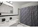 Bathroom features geometric shower curtain and white tiling at 1301 Cambridge Dr, Leesburg, FL 34748