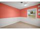 Cozy bedroom with coral walls and a bright window at 1301 Cambridge Dr, Leesburg, FL 34748