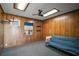 Room with wood paneling, a futon and window AC unit at 1301 Cambridge Dr, Leesburg, FL 34748