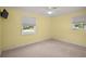 Well-lit bedroom with yellow walls and dual windows at 1301 Cambridge Dr, Leesburg, FL 34748